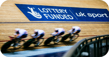 Four bicycle rider on a race with a Lottery Funded logo at the background and UK sport